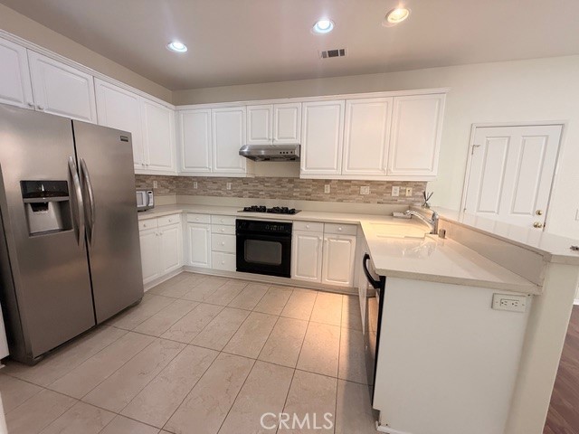 5 Del Mar Irvine, CA 92602 - Photo 4 of 15 a kitchen with stainless steel appliances granite countertop a refrigerator sink and cabinets