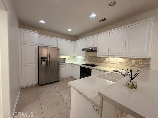 a kitchen with stainless steel appliances granite countertop a refrigerator sink and cabinets