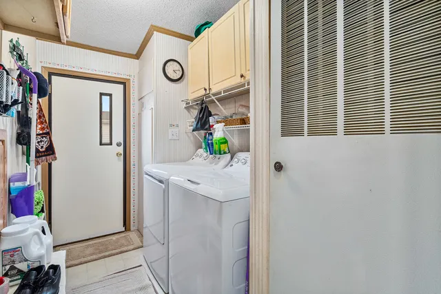 a view of washer and dryer with bathroom in the background