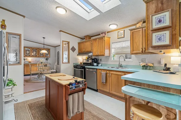a kitchen with granite countertop a sink stove and refrigerator