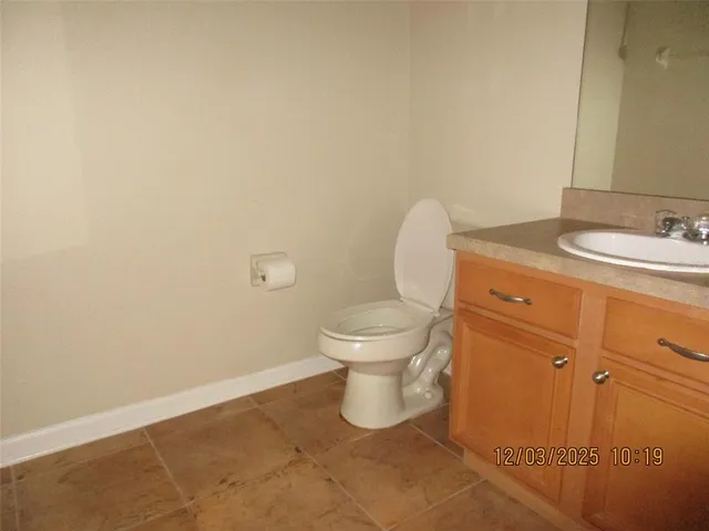 a bathroom with a granite countertop toilet and a sink