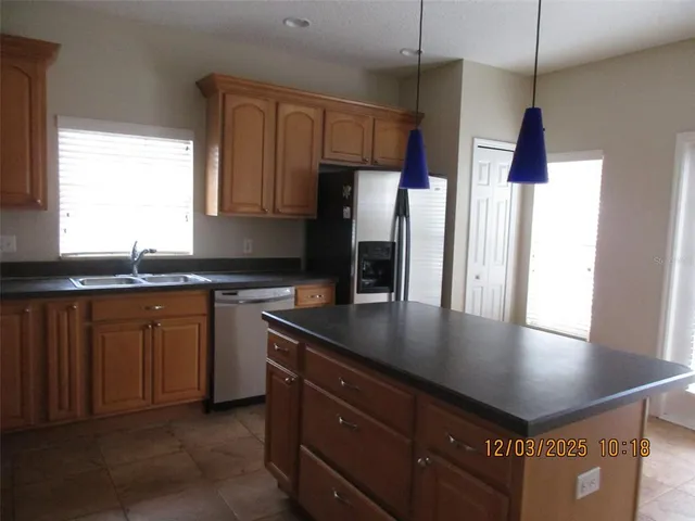 a kitchen with stainless steel appliances granite countertop a sink refrigerator and microwave