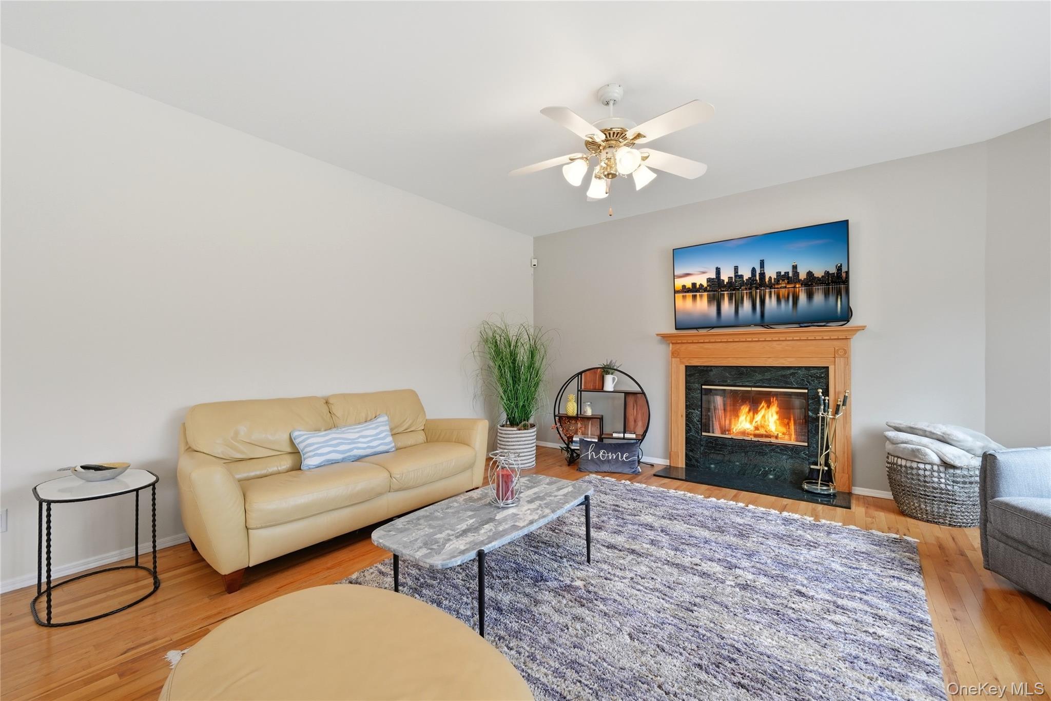 5 Mill Race Road Hampton Bays, NY 11946 - Photo 12 of 34 a living room with furniture a fireplace and a flat screen tv