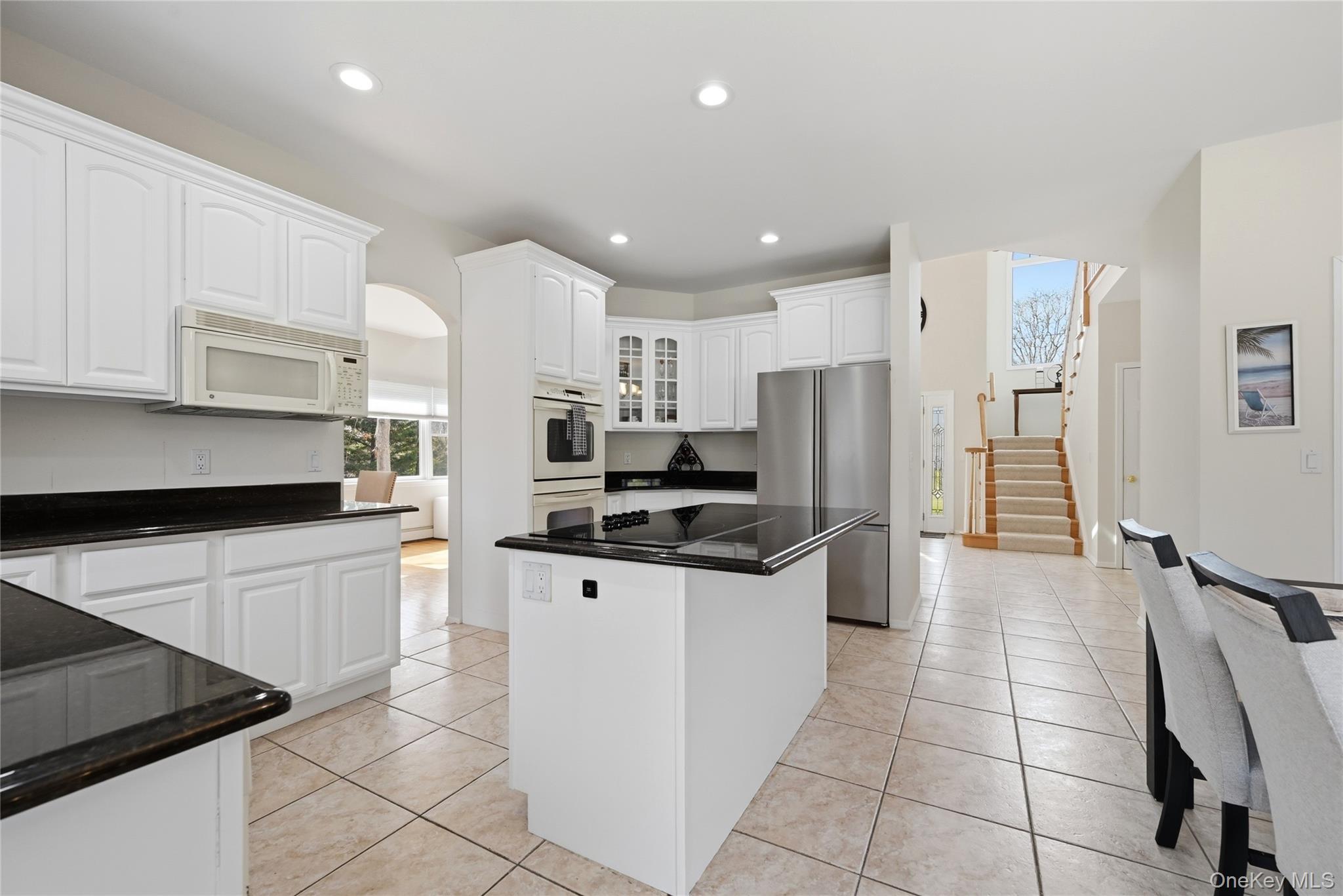 5 Mill Race Road Hampton Bays, NY 11946 - Photo 16 of 34 a kitchen with stainless steel appliances a refrigerator sink stove and cabinets