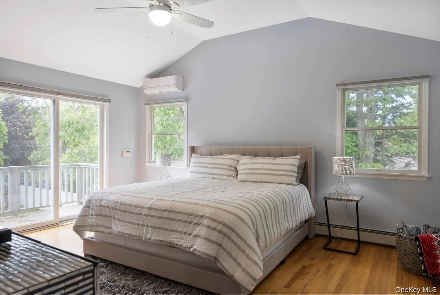 5 Mill Race Road Hampton Bays, NY 11946 - Photo 22 of 34 a bedroom with a bed a chandelier and a window