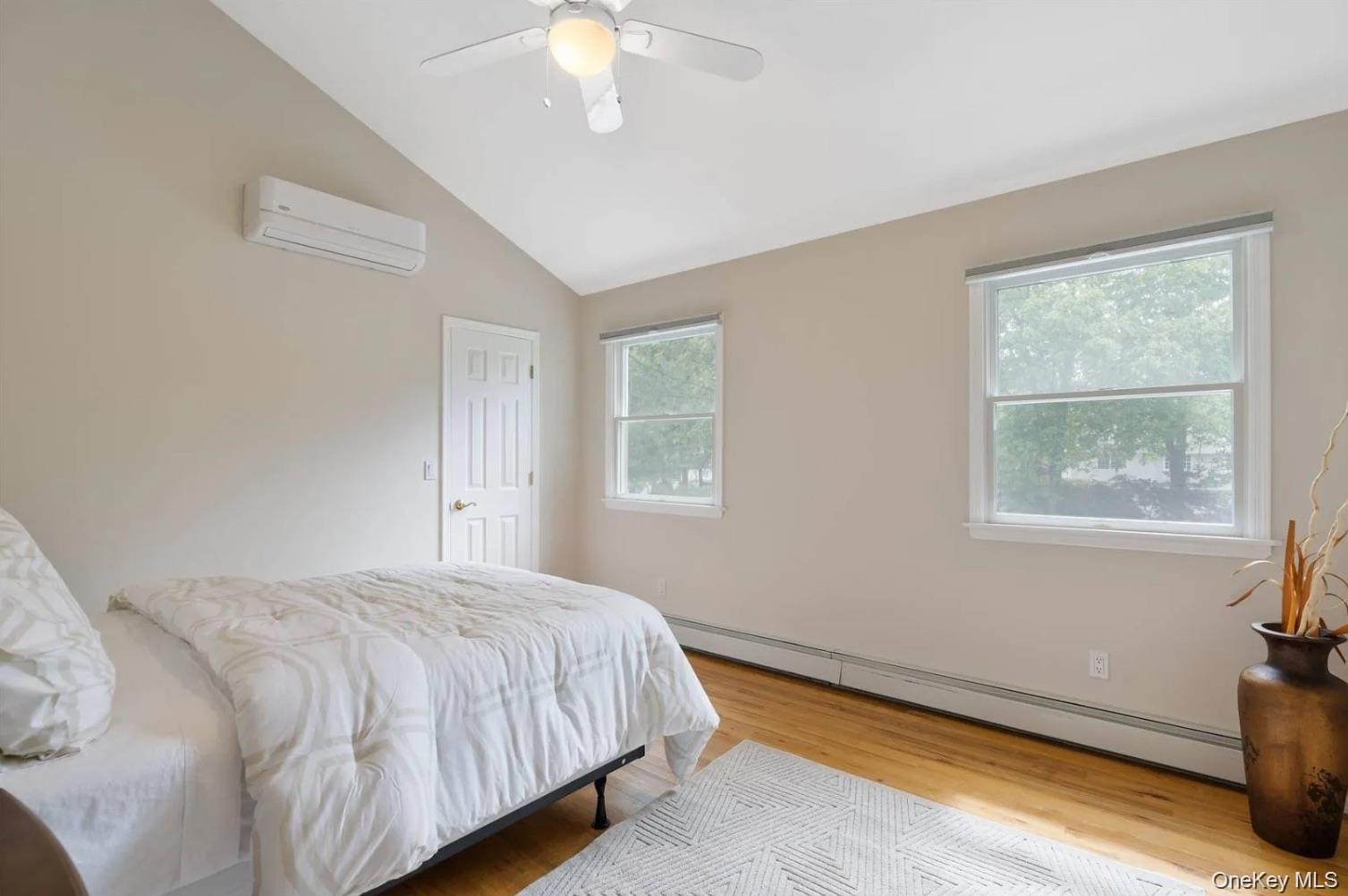 5 Mill Race Road Hampton Bays, NY 11946 - Photo 30 of 34 a bedroom with a bed and a chandelier
