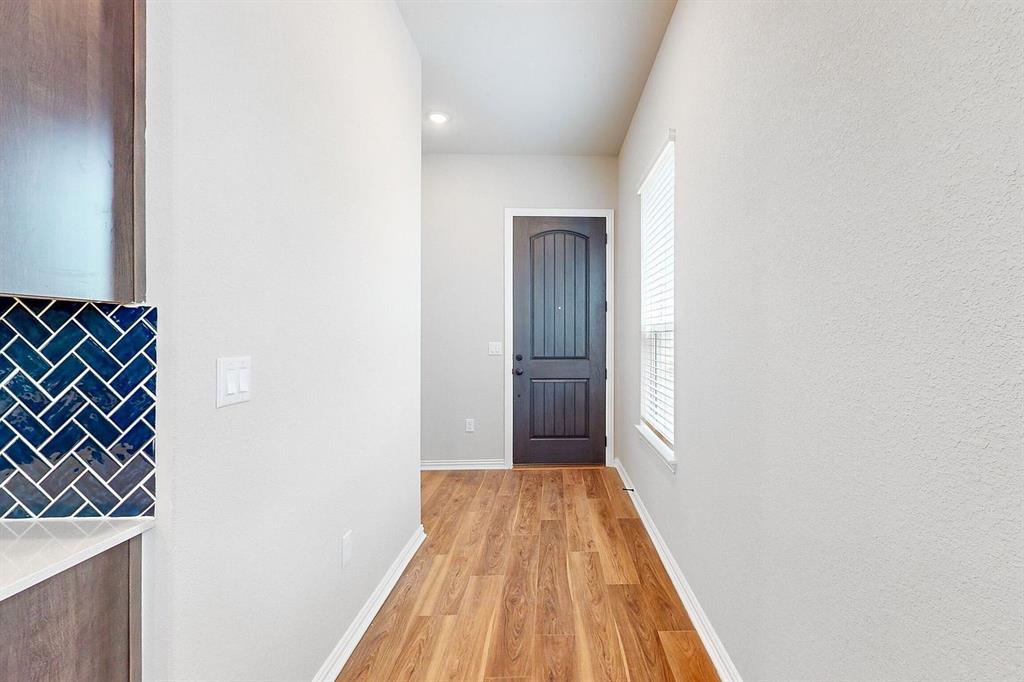 4907 Escape Rivera Drive Austin, TX 78747 - Photo 20 of 28 A welcoming entry hall with rich wood flooring leads to a robust front door, featuring a convenient adjacent kitchen counter.
