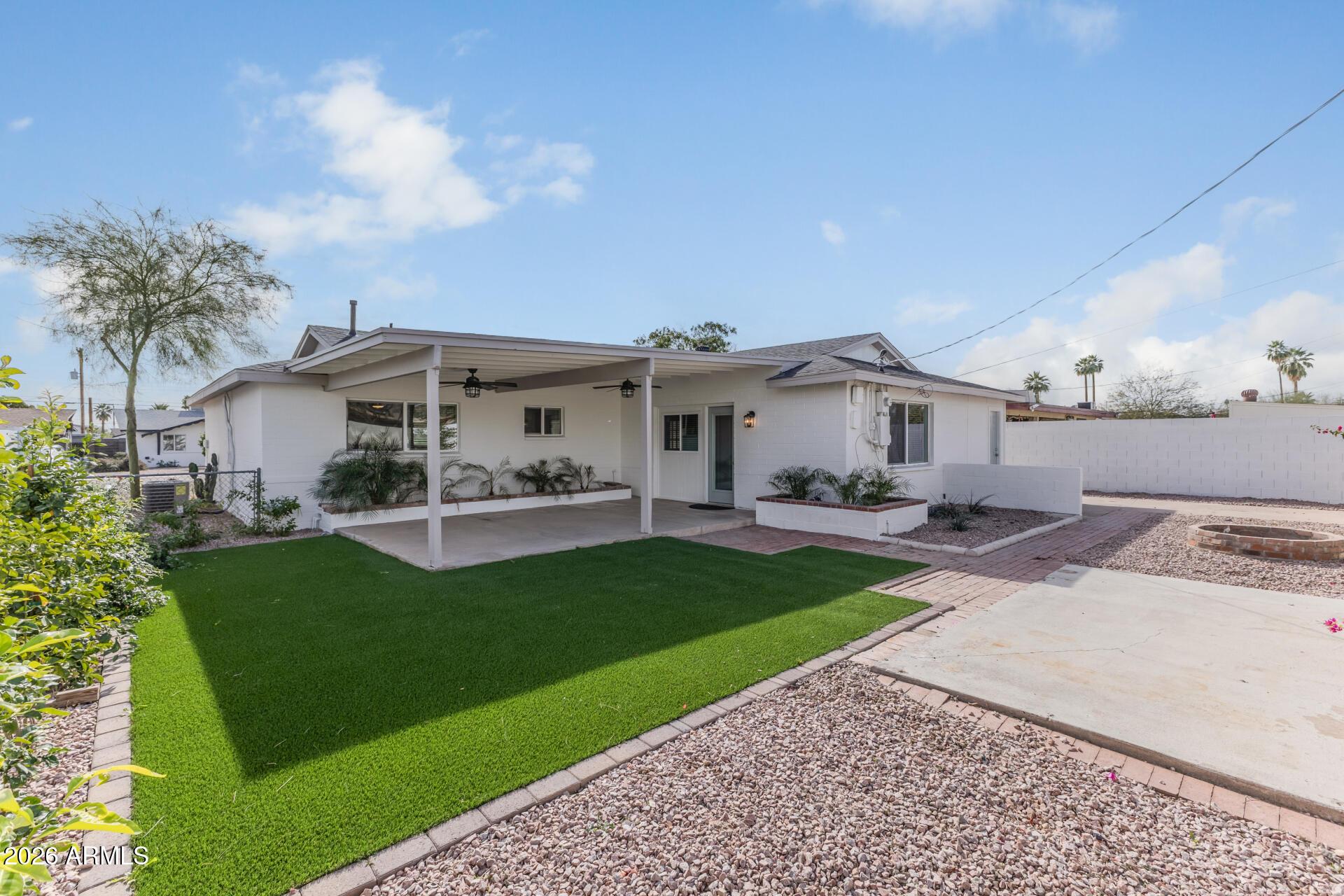 424 East Fillmore Street Tempe, AZ 85288 - Photo 15 of 20 a view of a white house in front of a yard with potted plants