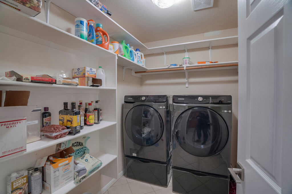 2724 Kickapoo Cavern Drive Pflugerville, TX 78660 - Photo 12 of 24 Functional laundry space featuring convenient shelving and a modern washer and dryer.