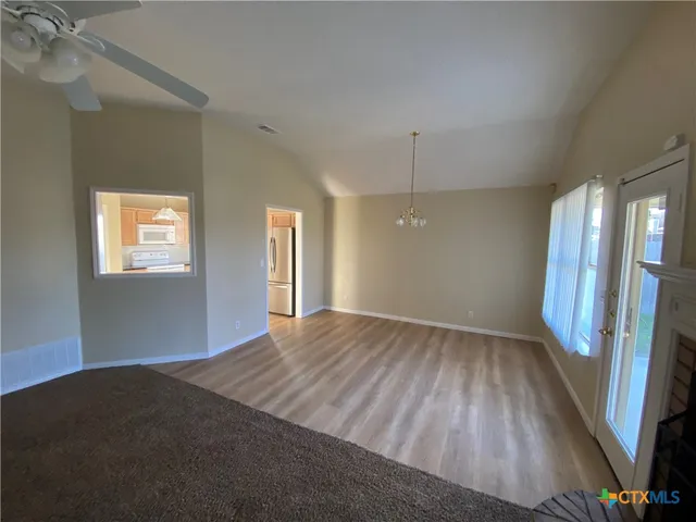 a view of a room with wooden floor and windows