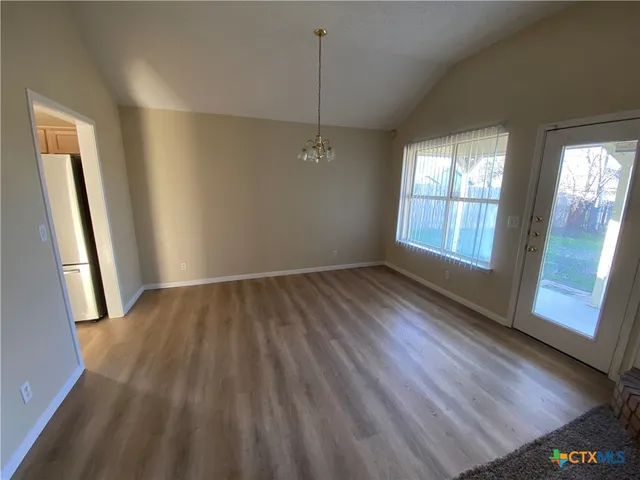 a view of a kitchen with wooden floor and electronic appliances