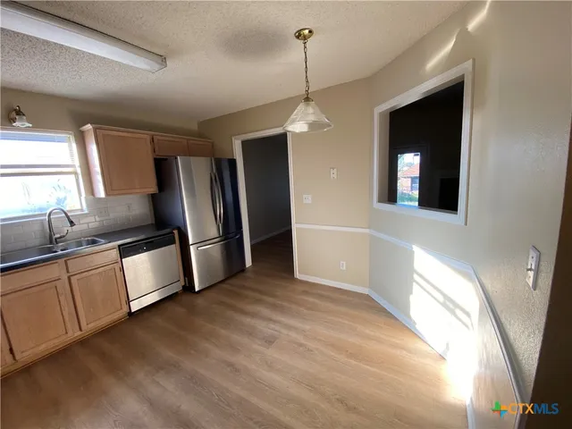 a kitchen with stainless steel appliances a refrigerator sink and microwave