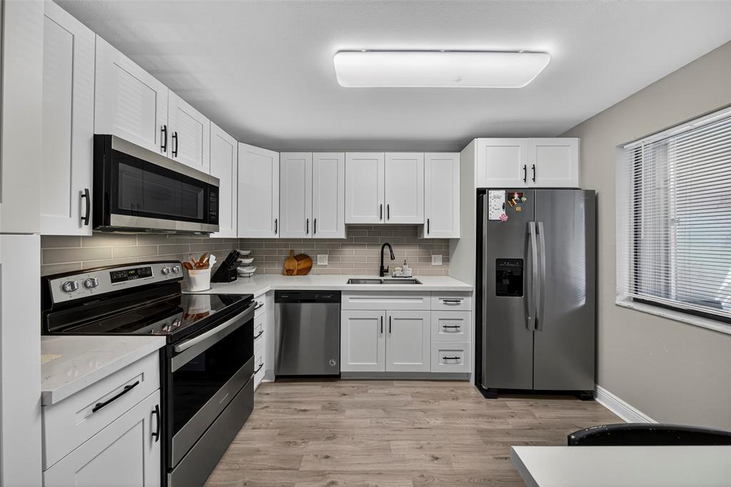 412 Lakeview Drive, Unit 202 Weston, FL 33326 - Photo 6 of 34 a kitchen with a refrigerator stove and white cabinets