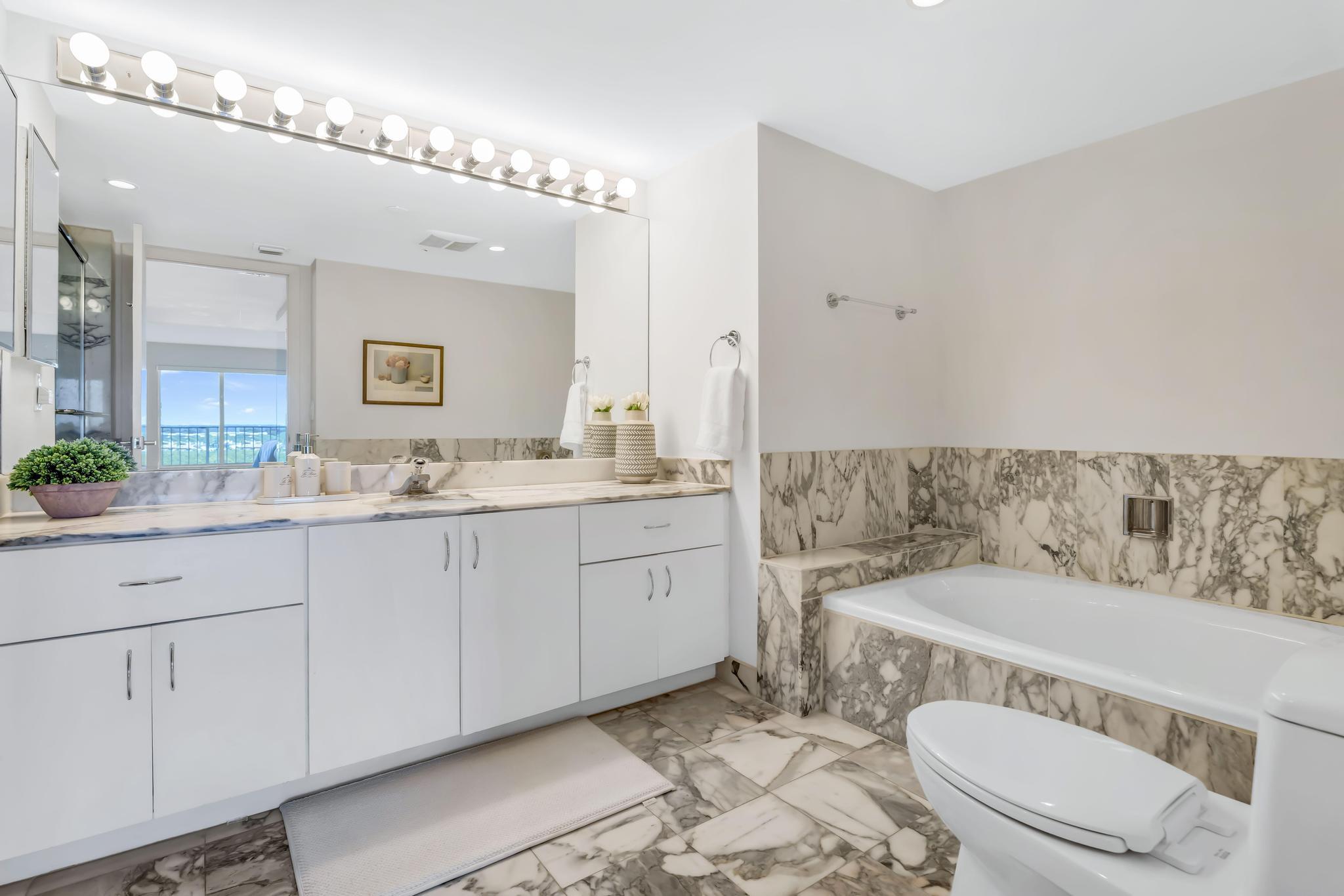 4301 North Ocean Boulevard, Unit 1002 Boca Raton, FL 33431 - Photo 22 of 71 a bathroom with a granite countertop sink mirror vanity and toilet