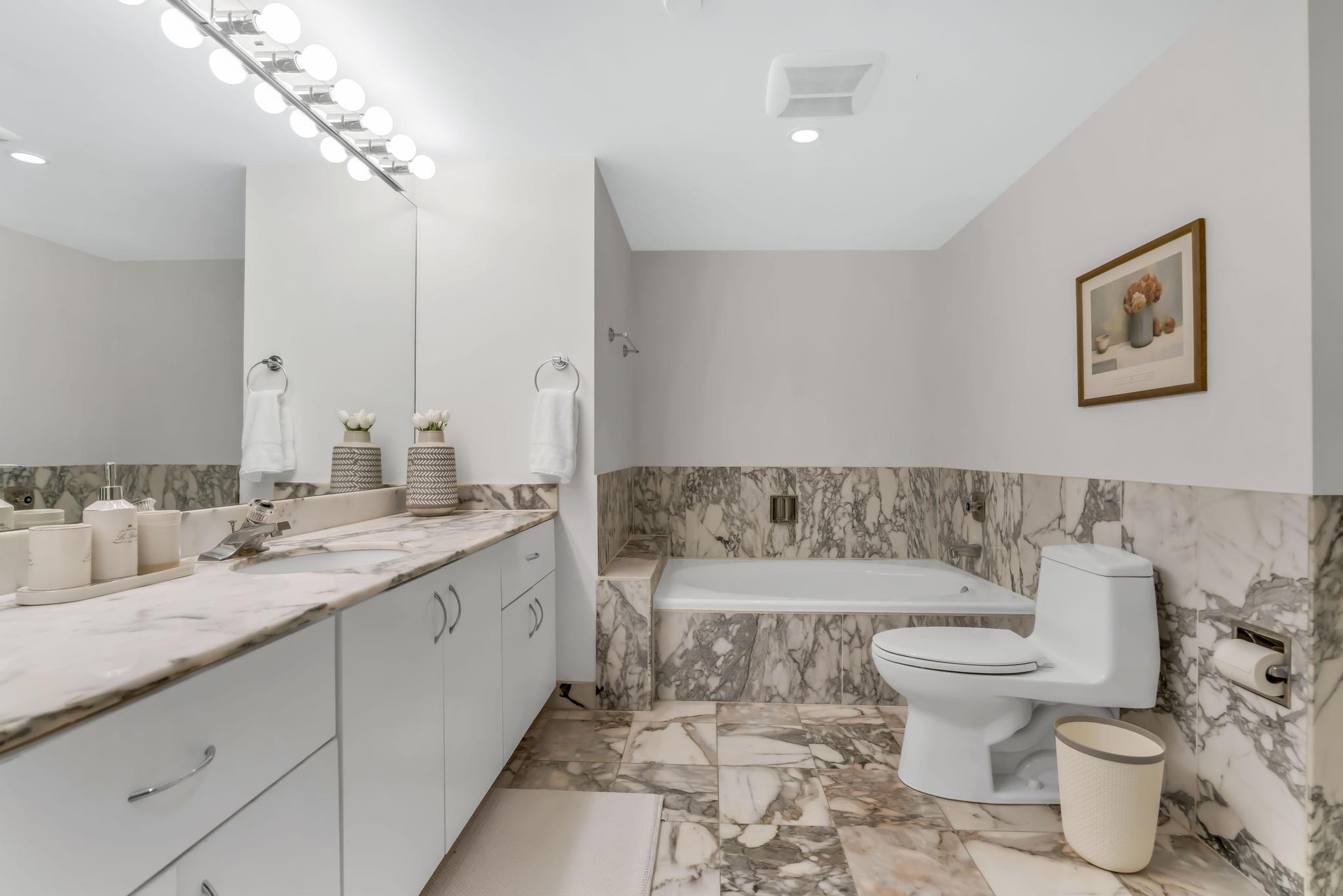 4301 North Ocean Boulevard, Unit 1002 Boca Raton, FL 33431 - Photo 24 of 71 a spacious bathroom with a granite countertop toilet a sink and a large mirror