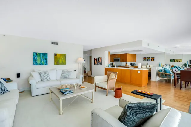 a kitchen with stainless steel appliances granite countertop a stove top oven a sink a dining table and chairs with wooden floor