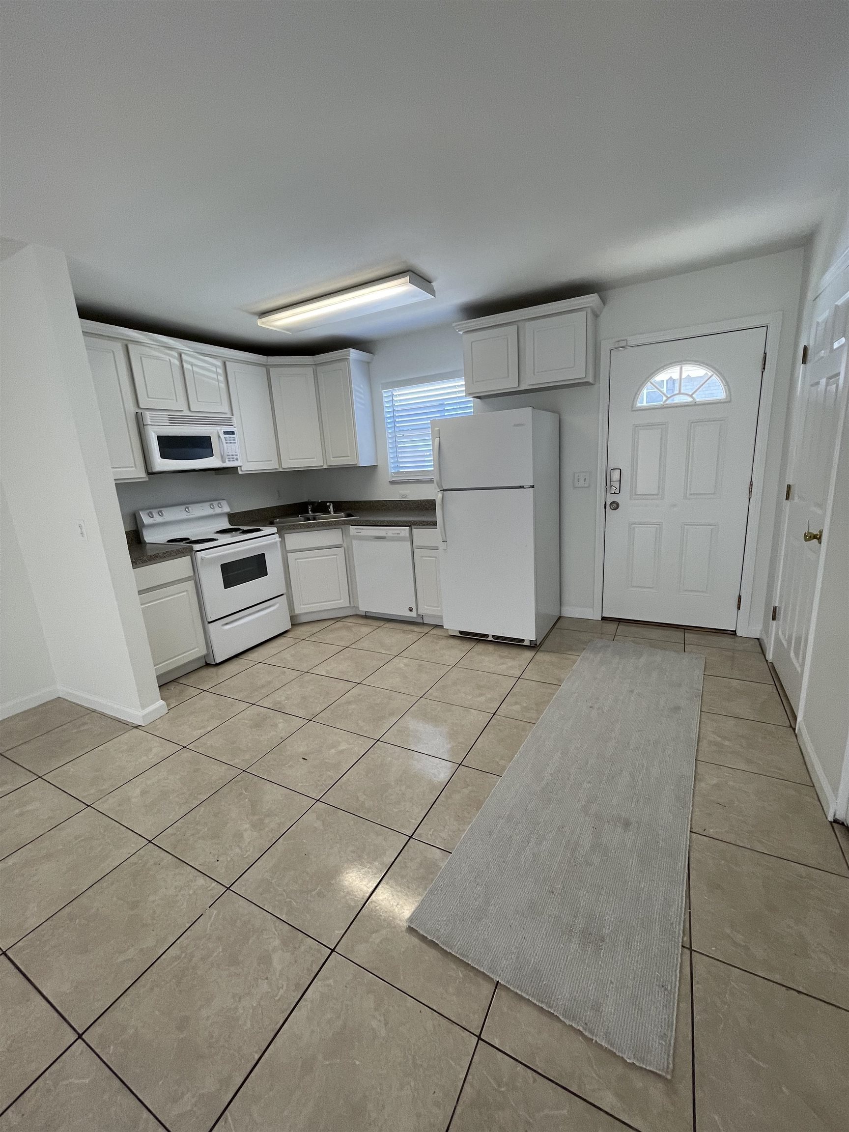 4420 Carter Road, Unit 29 St. Augustine, FL 32086 - Photo 10 of 15 a kitchen with granite countertop a stove a sink and a refrigerator