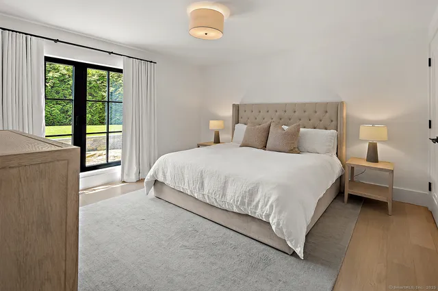 a bedroom with a bed and a large window