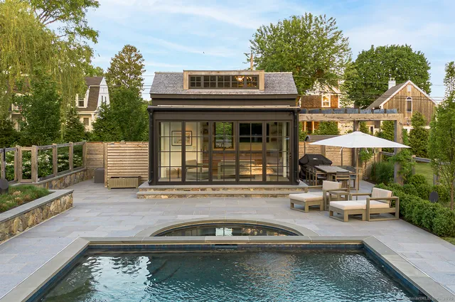 a view of a house with pool and chairs in a patio