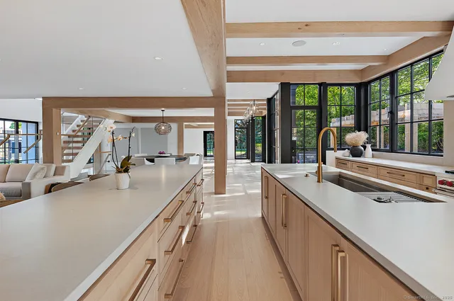 a large kitchen with kitchen island a large window in it