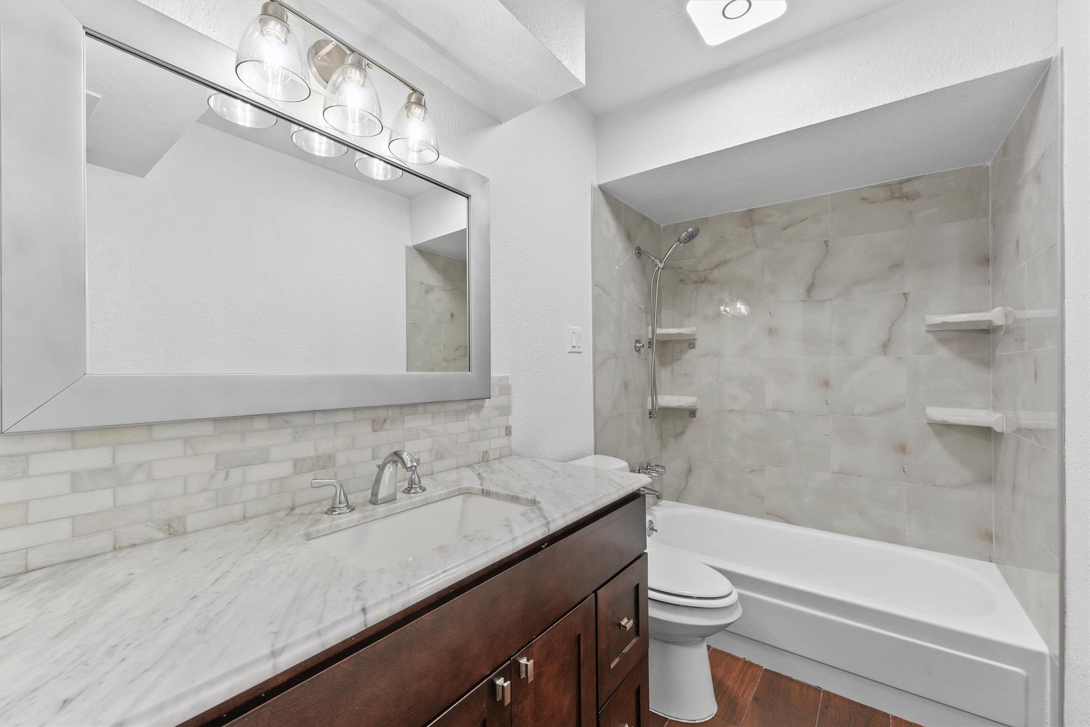 11550 Chimney Rock Road, Unit 536 Houston, TX 77035 - Photo 16 of 28 Primary bathroom - totally renovated with updated countertop, light fixture and mirror, toilet, and tub/shower combo