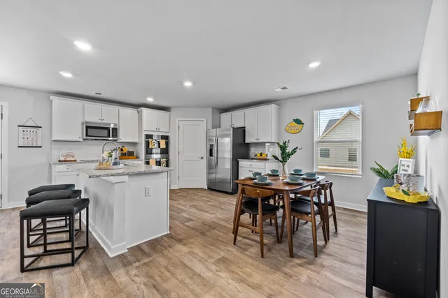 a kitchen with stainless steel appliances a refrigerator a stove a microwave oven a sink with island and chairs