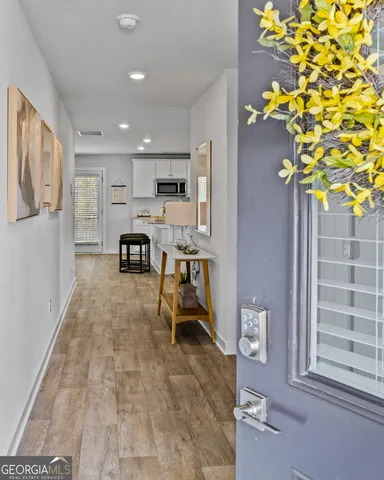 a view of a hallway with wooden floor and furniture