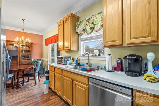 a kitchen with stainless steel appliances a sink window and cabinets
