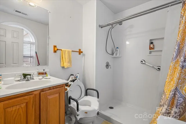 a bathroom with a sink toilet vanity and shower