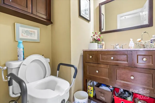 a bathroom with a toilet mirror and vanity