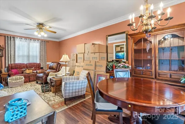 a dining room with furniture a chandelier and wooden floor