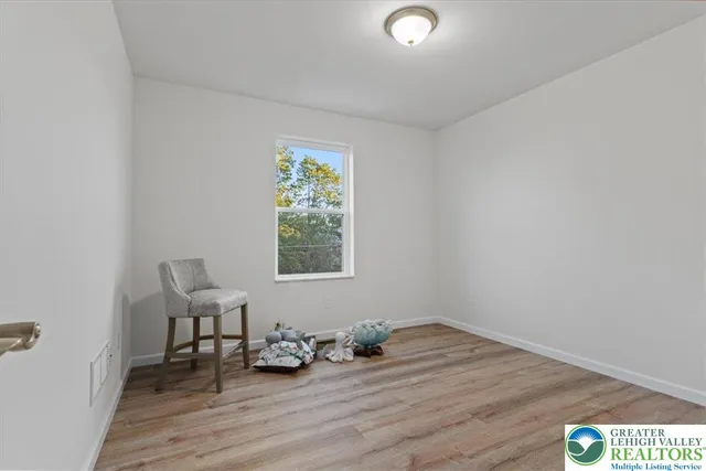 an empty room with wooden floor and a window