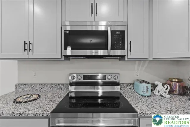 a kitchen with granite countertop a stove a microwave and cabinets