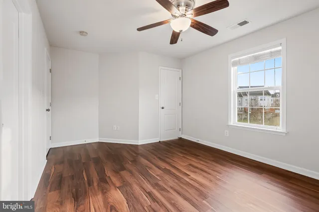 wooden floor in an empty room with a window