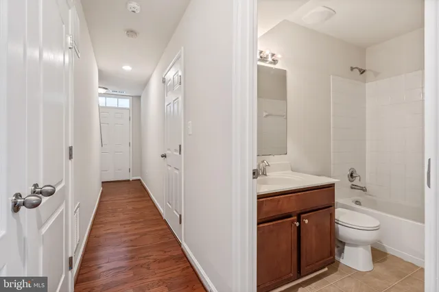 a bathroom with a granite countertop sink a toilet and shower
