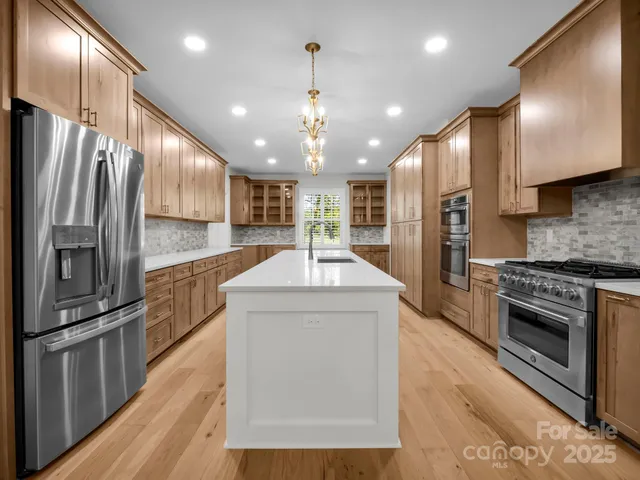a kitchen with kitchen island a counter top space stainless steel appliances and cabinets