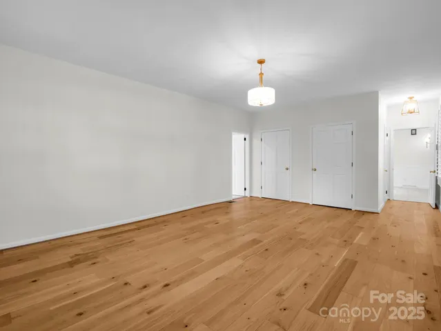 a view of empty room with window and wooden floor