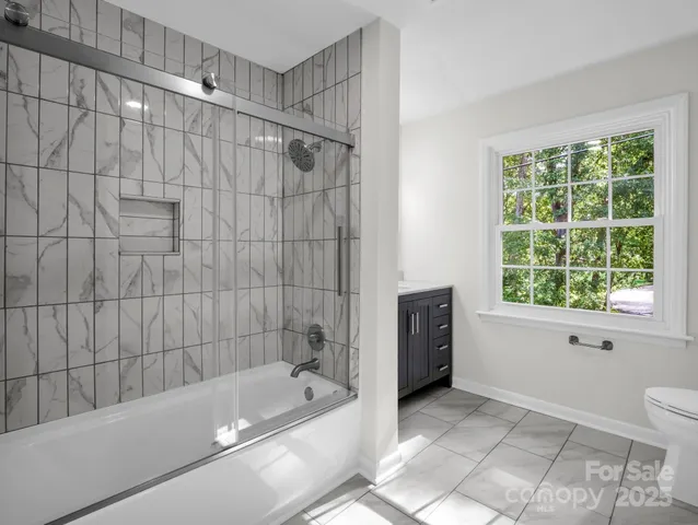 a bathroom with a granite countertop sink and a window