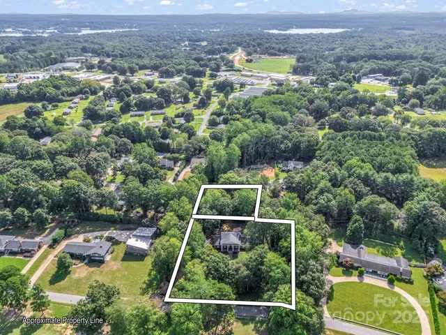 an aerial view of residential houses with outdoor space and trees