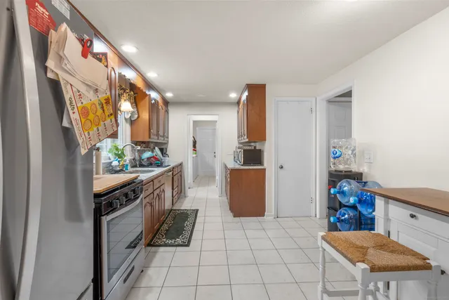 a kitchen with stainless steel appliances granite countertop a refrigerator and a stove