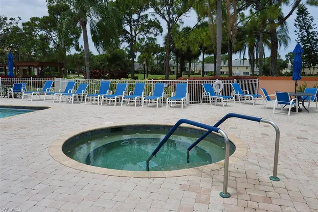 a view of a house with a big yard and potted plants and large tree