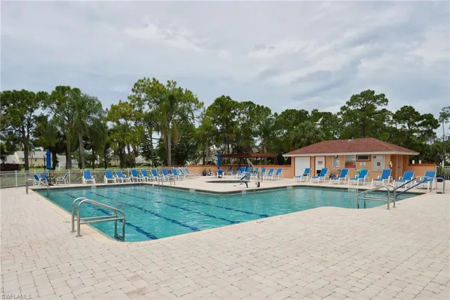 a view of a tennis ground with large trees