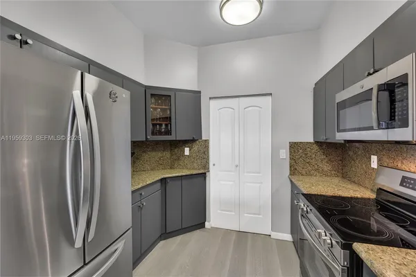 a kitchen with stainless steel appliances granite countertop a refrigerator and a stove top oven