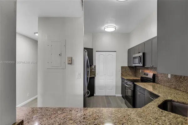 a kitchen with granite countertop a refrigerator and a sink
