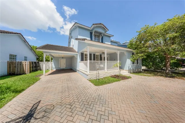 a front view of a house with a yard and potted plants