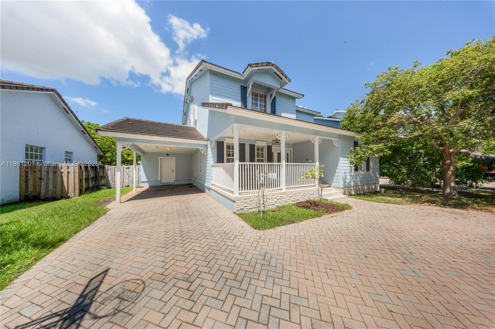 a front view of a house with a yard and potted plants