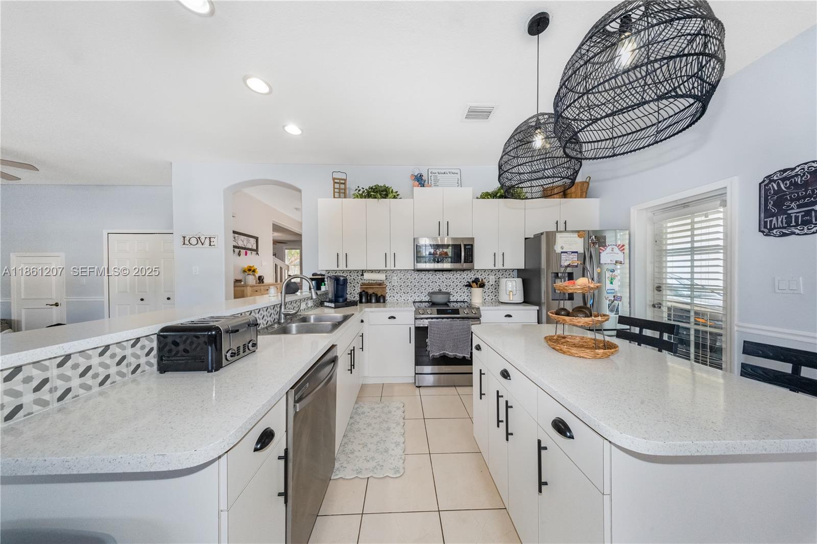 9822 Southwest 161st Place Miami, FL 33196 - Photo 17 of 47 a kitchen with a sink a stove and cabinets
