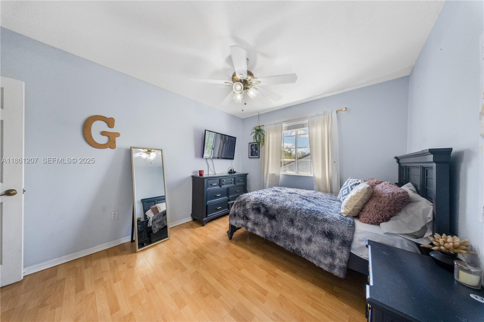 9822 Southwest 161st Place Miami, FL 33196 - Photo 35 of 47 a living room with furniture and a flat screen tv