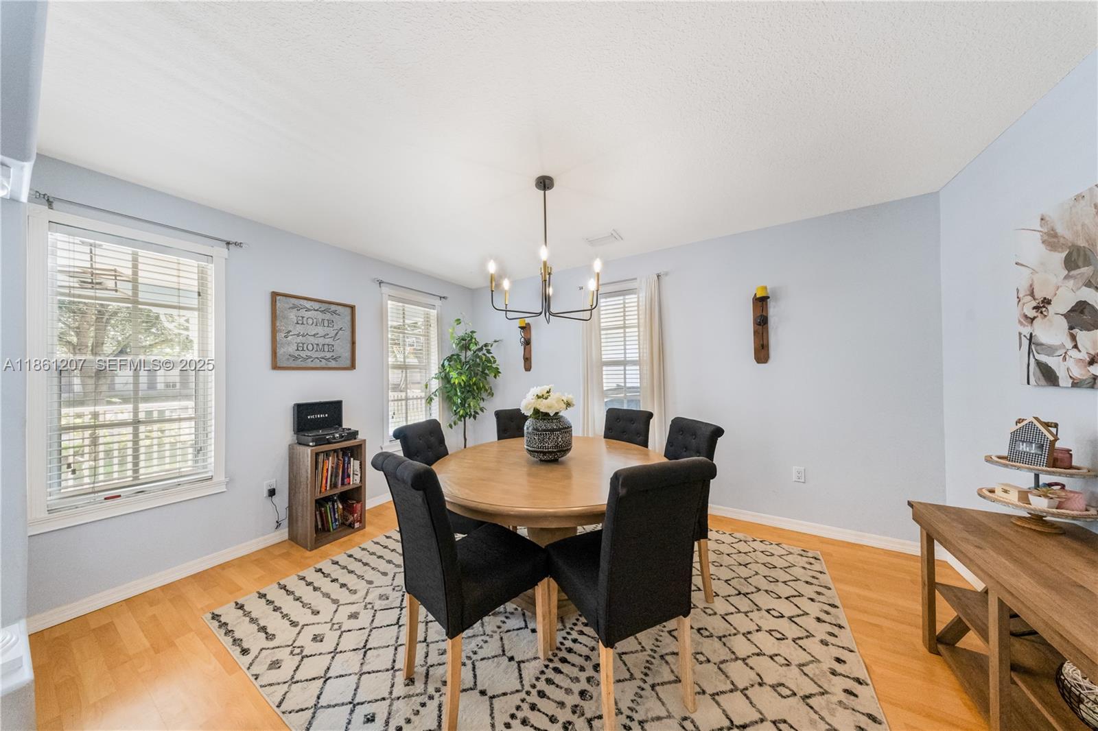 9822 Southwest 161st Place Miami, FL 33196 - Photo 10 of 47 a dining room with furniture a rug and wooden floor