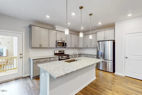a kitchen with stainless steel appliances granite countertop a refrigerator a sink and a stove